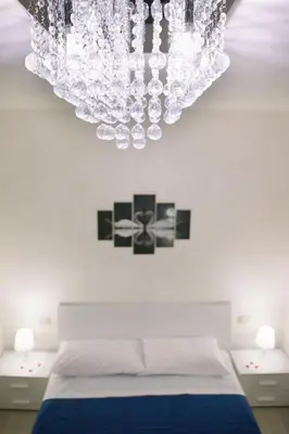 a chandelier hanging over a bed in a bedroom at Light Blue in Balestrate