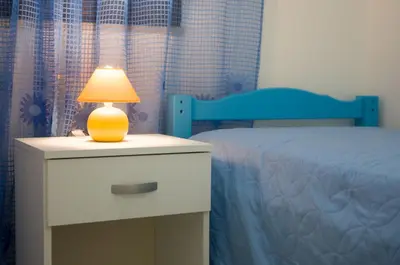 a lamp on a night stand next to a bed at Light Blue in Balestrate