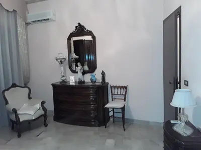 a room with a dresser and a mirror and two chairs at Elimo Affittacamere - Casa Vacanze di Scardino Leonardo in Poggioreale