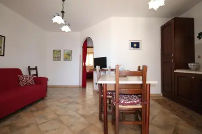a dining room with a table and chairs and a couch at casa Vincenzo in Castelluzzo