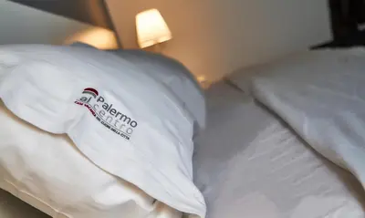 a bed with a white pillow with a sign on it at Palermo al Centro - Appartamento Maestri in Palermo