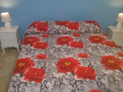 a bed with red flowers on top of it at I Cinque Continenti in Palermo