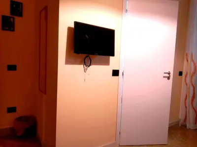 a flat screen tv on a wall next to a door at L'Aquilone B&B in Palermo