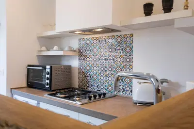 a kitchen with a sink and a stove and a microwave at Overseas - Penthouse with terrace - Attico - Palazzo San Matteo in Palermo