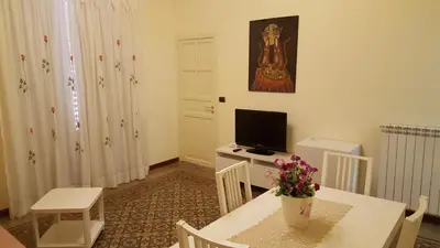 a living room with a table and a television at CasaLù in Palermo