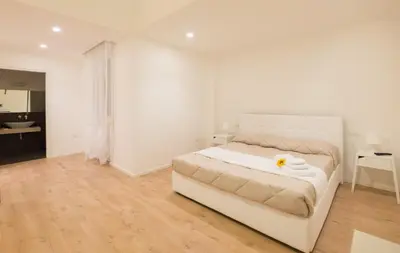 a white bedroom with a bed and a desk at Dante 58 in Palermo