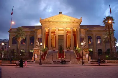 a large building with a building with palm trees in front at Dante 58 in Palermo