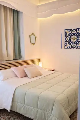 a bedroom with a large white bed with pink pillows at B&B 091 in Palermo