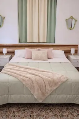 a bedroom with a large white bed with pink pillows at B&B 091 in Palermo
