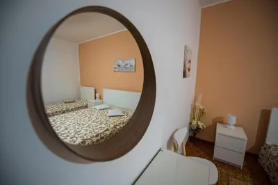 a mirror reflecting a bedroom with a bed in a room at Alle Vigne Affittacamere in Alcamo