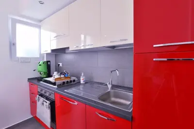 a kitchen with red cabinets and a sink at B&B Le Porte Del Centro in Palermo
