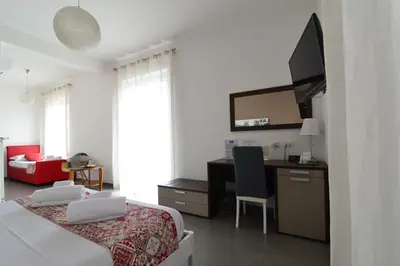 a hotel room with a bed and a desk and a tv at B&B Le Porte Del Centro in Palermo