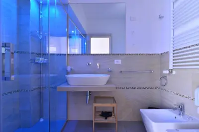 a bathroom with a sink and a glass shower at B&B Le Porte Del Centro in Palermo