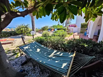 a hammock under a tree in a yard at Villa Hibisco in San Vito lo Capo