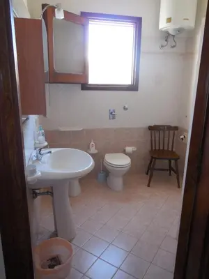 a bathroom with a sink and a toilet and a window at New Eden in San Vito lo Capo