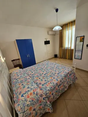 a large bed in a room with a blue cabinet at New Eden in San Vito lo Capo
