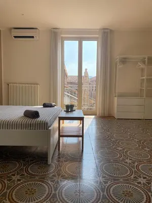 a bedroom with a bed and a table and a window at Le Stanze di Federico apartment e Costanza Luxury apartment in Palermo