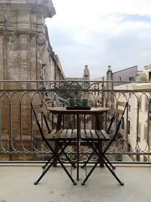 a table with two cups on top of a balcony at Le Stanze di Federico apartment e Costanza Luxury apartment in Palermo