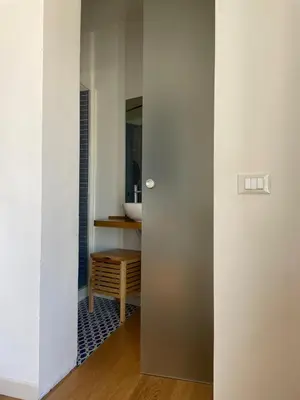 a bathroom with a door leading to a sink at Le Stanze di Federico apartment e Costanza Luxury apartment in Palermo