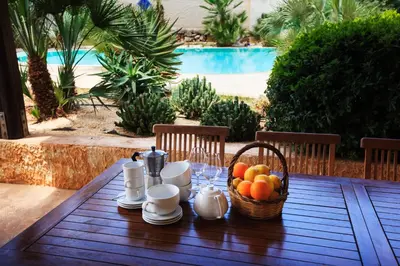 a wooden table with a basket of fruit on it at Villa Sole in San Vito lo Capo