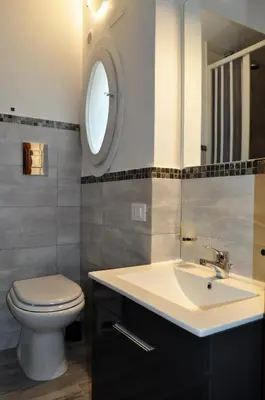 a bathroom with a sink and a toilet and a mirror at Camere da Mariolina in Macari