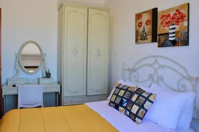 a bedroom with a bed and a desk and a mirror at Camere da Mariolina in Macari