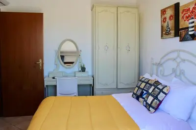 a bedroom with a bed and a desk with a mirror at Camere da Mariolina in Macari