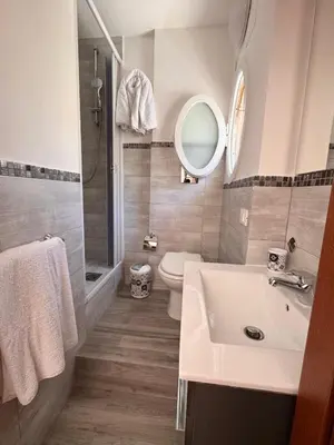 a bathroom with a sink and a toilet and a mirror at Camere da Mariolina in Macari