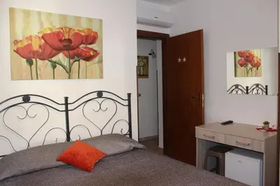 a bedroom with a bed and a painting on the wall at Camere da Mariolina in Macari