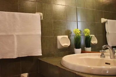 a bathroom with a sink and a urinal and towels at B&B Pisani in Palermo