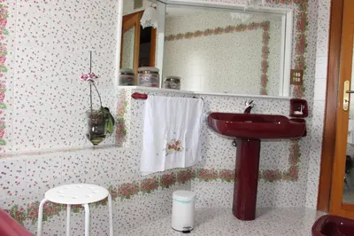 a bathroom with a red sink and a mirror at B&B Pisani in Palermo