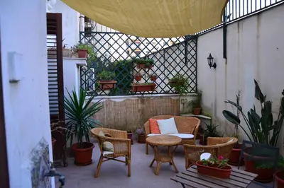 a patio with a table and chairs and plants at il lapino in Palermo