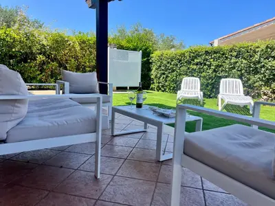 a patio with two chairs and a table at Villa Camelie in Campofelice di Roccella
