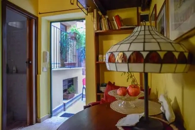a table with a lamp and a bowl of apples on it at Millimetro in Palermo