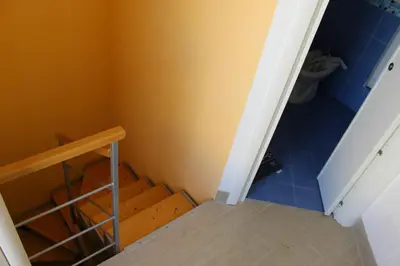 a bathroom with a toilet and a staircase with blue tiles at Casa Vacanze Roccella Beach in Campofelice di Roccella