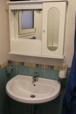 a bathroom with a white sink and a mirror at Casa Vacanze Roccella Beach in Campofelice di Roccella