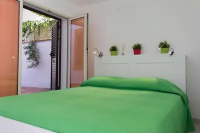 a bedroom with a green bed and a window at Piccola Oasi in Mondello