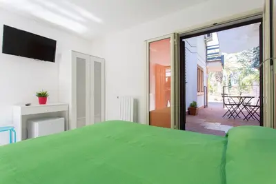 a bedroom with a green bed and a sliding glass door at Piccola Oasi in Mondello