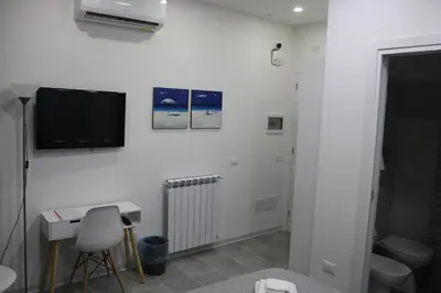 a white room with a tv and a desk and a chair at Ri.Mo's Rent Room in Palermo