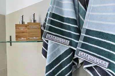 a pile of striped towels on a shelf in a bathroom at Casa Nostra B&B in Palermo