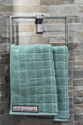a green towel hanging on a towel rack in a shower at Casa Nostra B&B in Palermo