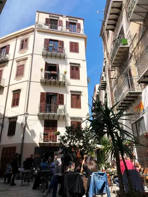 a group of people sitting in front of a building at Casa Nostra B&B in Palermo