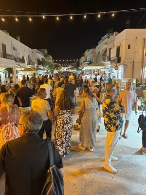 a crowd of people standing around in a street at night at holiday home LG in San Vito lo Capo