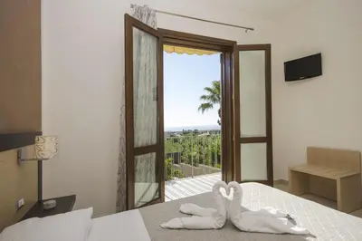 a bedroom with two towels on a bed with a window at B&B Coppola in Castelluzzo