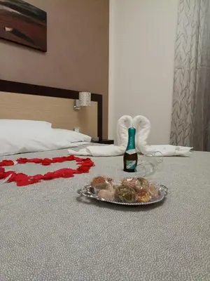 a bottle of wine and a plate of food on a bed at B&B Coppola in Castelluzzo