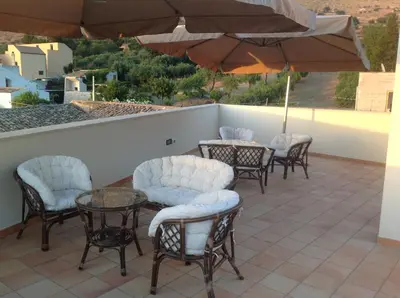 a patio with tables and chairs and an umbrella at B&B Coppola in Castelluzzo