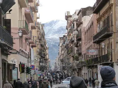 a crowd of people walking down a street with buildings at Casa Principe Maqueda in Palermo
