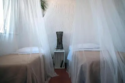 a bedroom with two beds with mosquito nets at Addumari in Palermo