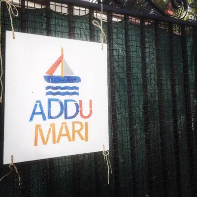 a sign on a fence that reads addiu mariti at Addumari in Palermo