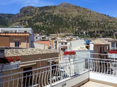 a view from the balcony of a building with a mountain in the background at White in Castellammare del Golfo